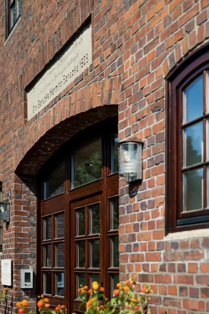 Eingang der Praxis mit Backsteinbogen und Inschrift von 1929