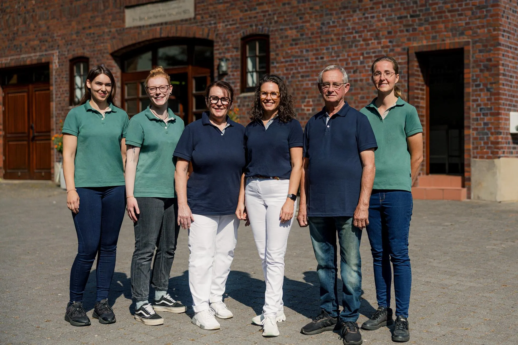 Das Praxisteam vor dem Backsteinhaus